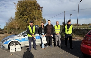 fotografie z działań, policjanci przy radiowozie i kontrolowanych pojazdach rozmawiają z kierowcami i wręczają pakiety edukacyjne